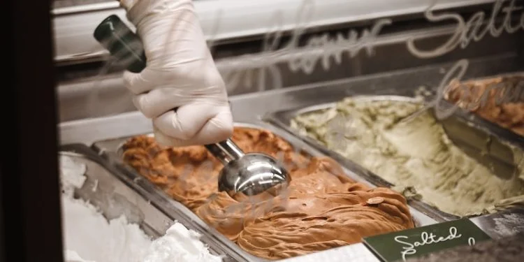 person in white gloves holding tray with food